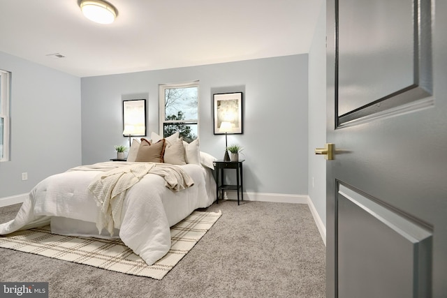 bedroom with visible vents, light colored carpet, and baseboards