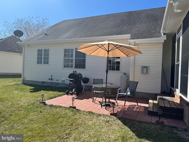 back of property with crawl space, a patio, a yard, and roof with shingles