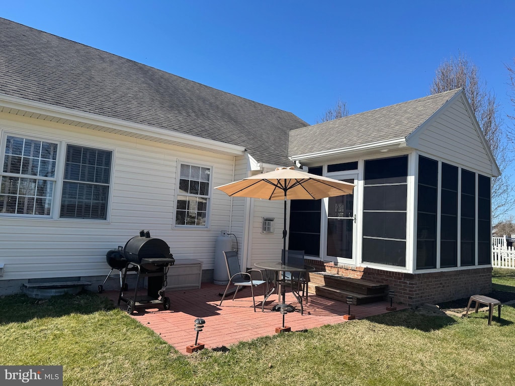 back of house with crawl space, a yard, roof with shingles, and a sunroom