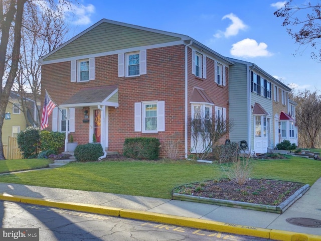 view of front of property featuring brick siding and a front yard