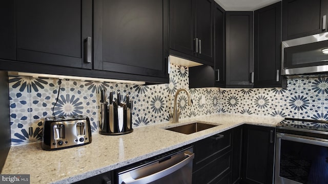 kitchen with a sink, stainless steel appliances, and dark cabinets
