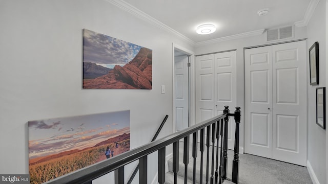 hallway with ornamental molding, baseboards, an upstairs landing, and visible vents