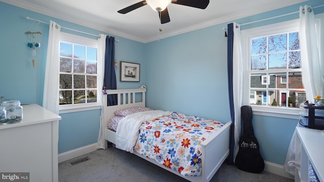 carpeted bedroom with crown molding, baseboards, ceiling fan, and visible vents