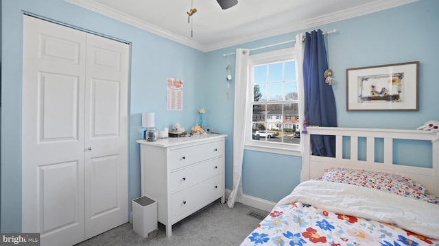 carpeted bedroom with a ceiling fan, a closet, ornamental molding, and baseboards