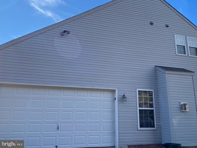 view of side of home featuring a garage and driveway