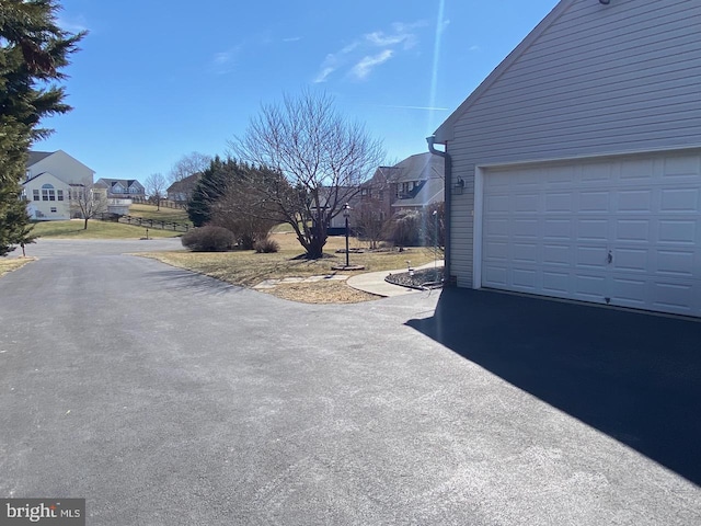 exterior space featuring aphalt driveway and a residential view