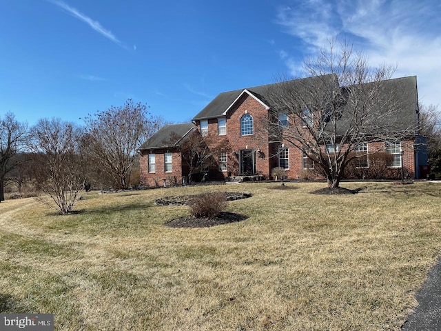 view of front of home with brick siding and a front yard