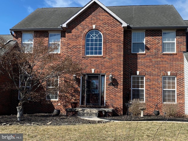 view of front of house with brick siding and a shingled roof