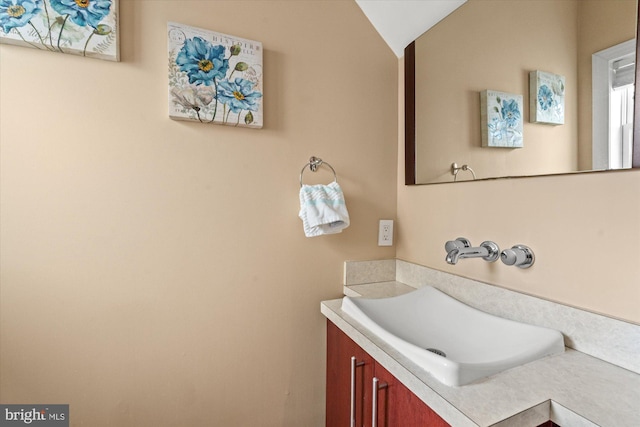 bathroom featuring lofted ceiling and vanity