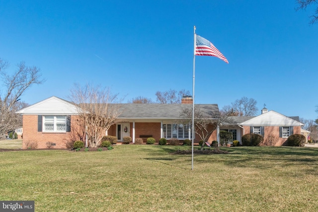 ranch-style home with crawl space, brick siding, a chimney, and a front lawn