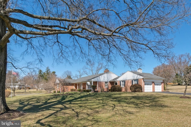 view of front of home with brick siding, a garage, aphalt driveway, and a front yard