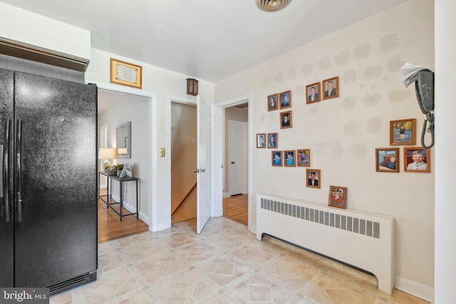 corridor featuring radiator and baseboards