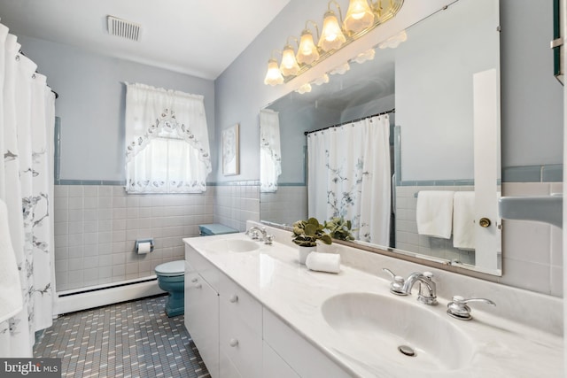 full bathroom featuring visible vents, a baseboard radiator, a sink, tile walls, and toilet