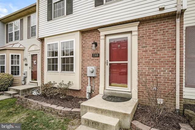 view of exterior entry featuring brick siding