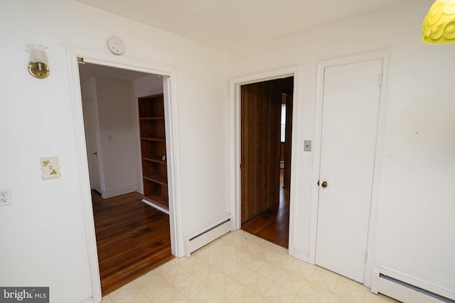 unfurnished bedroom with a baseboard heating unit and light floors