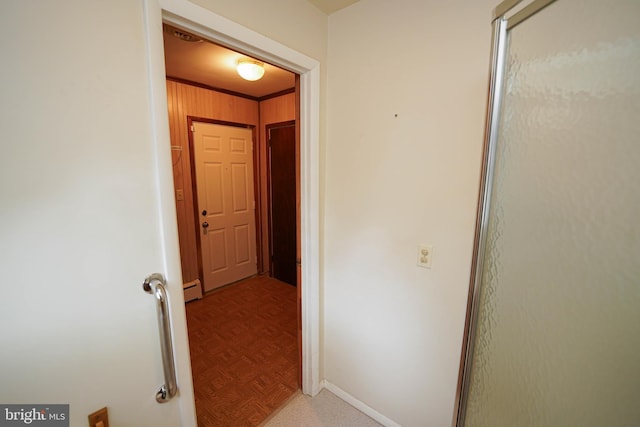 hall featuring a baseboard radiator, baseboards, and ornamental molding