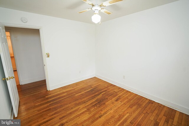 empty room with baseboards and hardwood / wood-style flooring