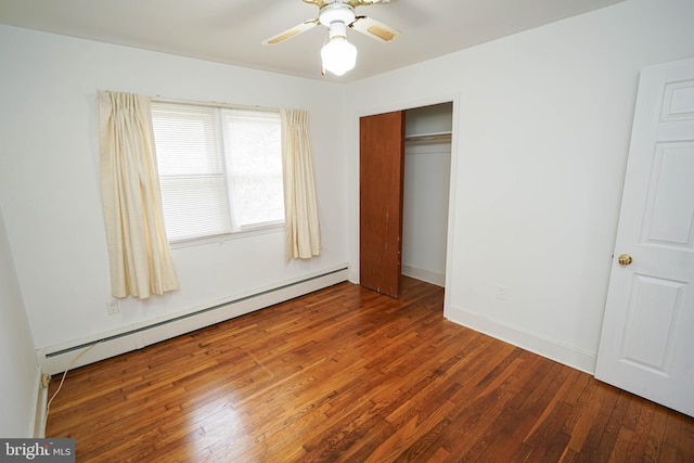 unfurnished bedroom featuring ceiling fan, baseboards, a baseboard radiator, a closet, and wood-type flooring