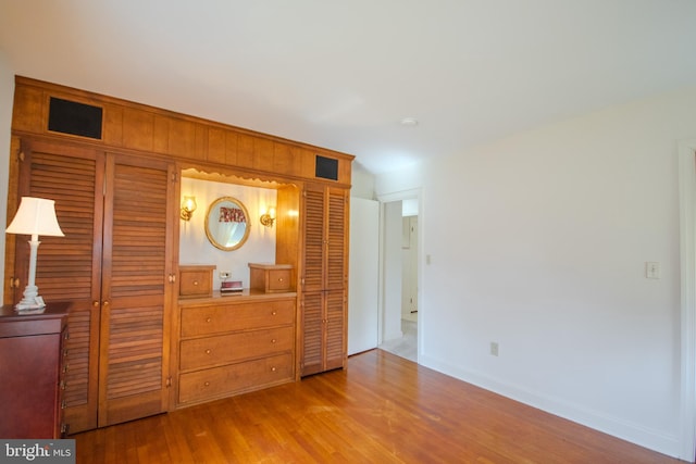 bedroom featuring visible vents, baseboards, and wood finished floors