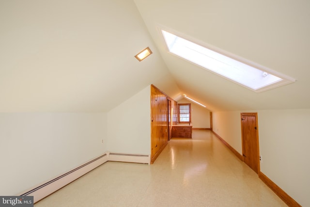 bonus room featuring vaulted ceiling with skylight, baseboards, and a baseboard radiator