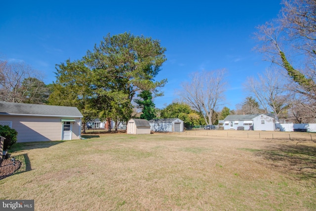 view of yard with an outbuilding, a shed, and fence