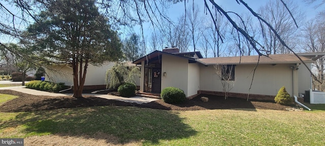 view of home's exterior featuring a lawn, central AC unit, and a chimney