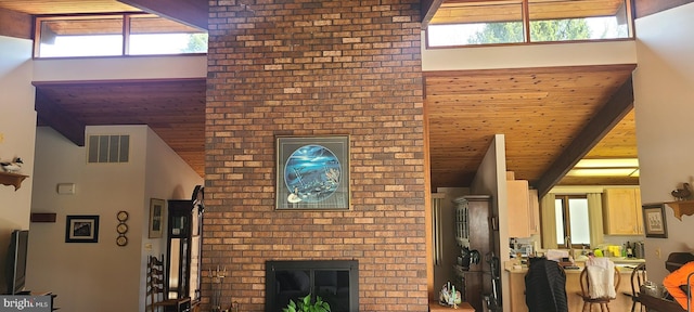 unfurnished living room with visible vents, beam ceiling, high vaulted ceiling, and wooden ceiling