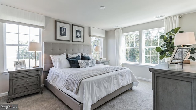 bedroom with visible vents, light colored carpet, and baseboards