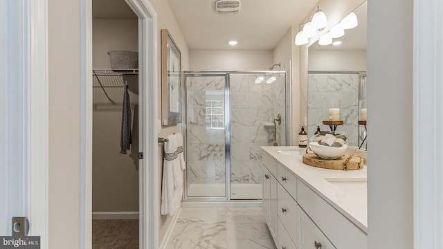 bathroom featuring a marble finish shower, visible vents, a spacious closet, double vanity, and marble finish floor