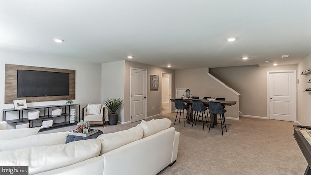 living room with recessed lighting, light colored carpet, and baseboards