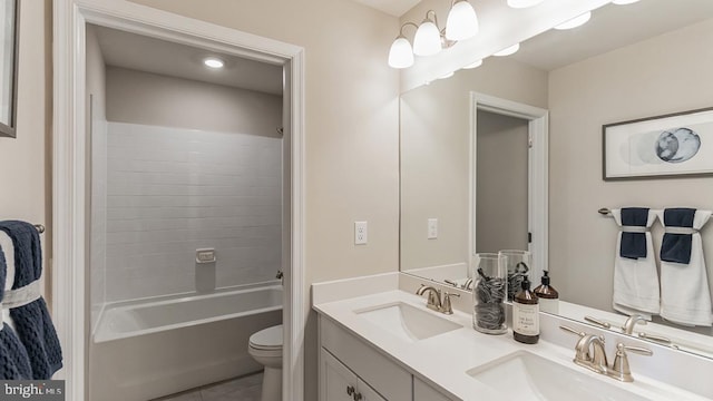 full bath featuring double vanity, washtub / shower combination, toilet, and a sink