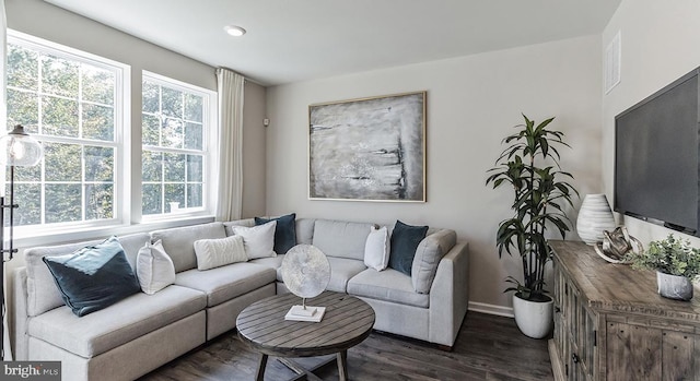 living area featuring dark wood-style floors, visible vents, and baseboards