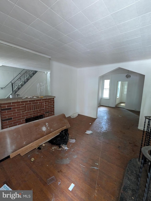 unfurnished living room featuring hardwood / wood-style floors and stairway