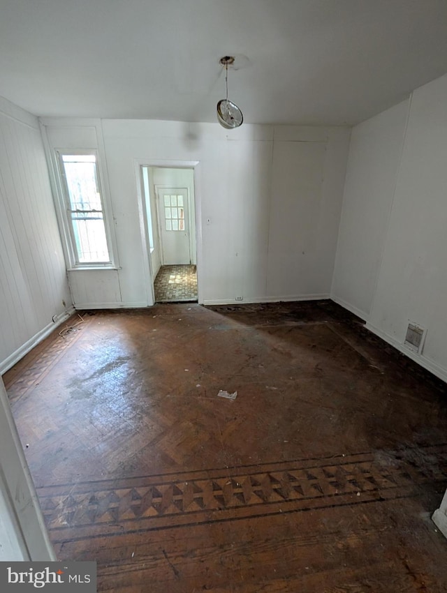 unfurnished room featuring baseboards and visible vents