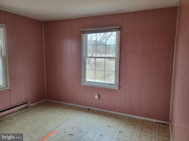 spare room featuring a wealth of natural light, baseboards, light floors, and baseboard heating