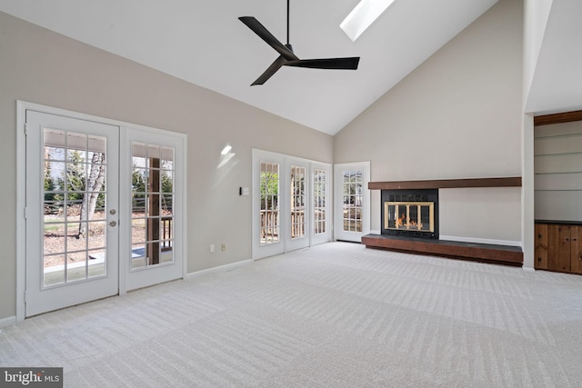 unfurnished living room featuring a glass covered fireplace, french doors, high vaulted ceiling, and carpet floors