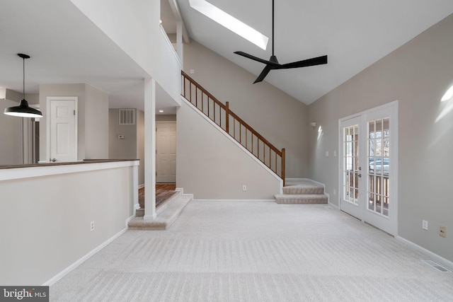 unfurnished living room with visible vents, stairway, carpet, and french doors