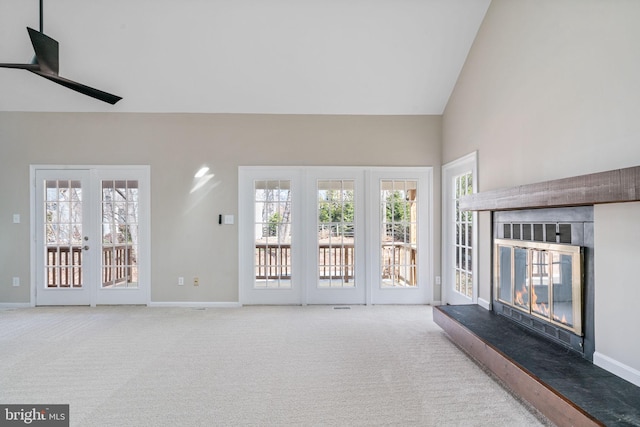 unfurnished living room with carpet, a glass covered fireplace, french doors, and baseboards