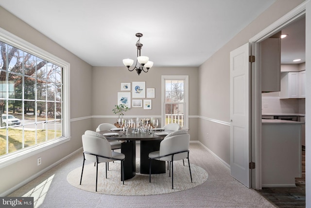 dining room featuring baseboards, an inviting chandelier, and carpet floors