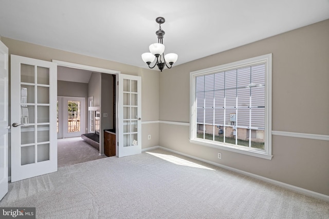 unfurnished room featuring french doors, baseboards, a chandelier, and carpet flooring