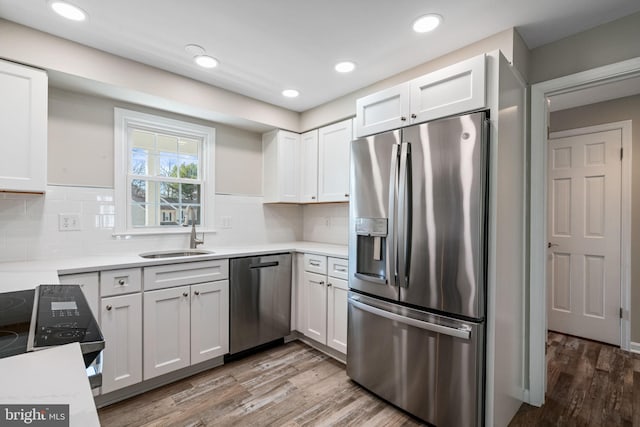 kitchen with light countertops, wood finished floors, appliances with stainless steel finishes, and a sink