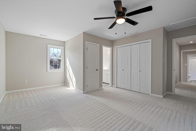 unfurnished bedroom featuring a ceiling fan, visible vents, baseboards, light carpet, and connected bathroom