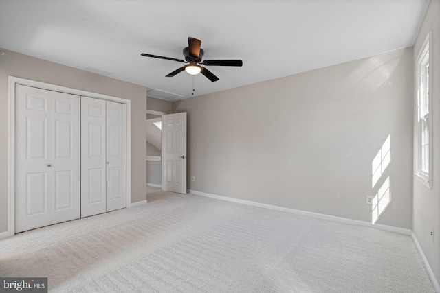 unfurnished bedroom with a closet, multiple windows, baseboards, and carpet