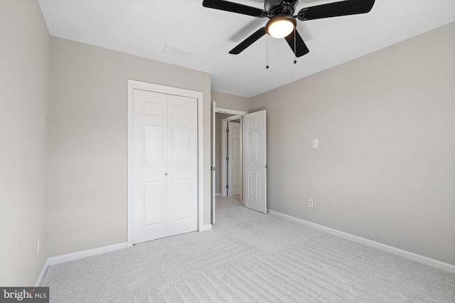 unfurnished bedroom featuring ceiling fan, light colored carpet, a closet, and baseboards