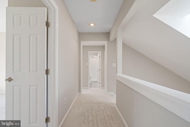 hall featuring baseboards, lofted ceiling with beams, and carpet