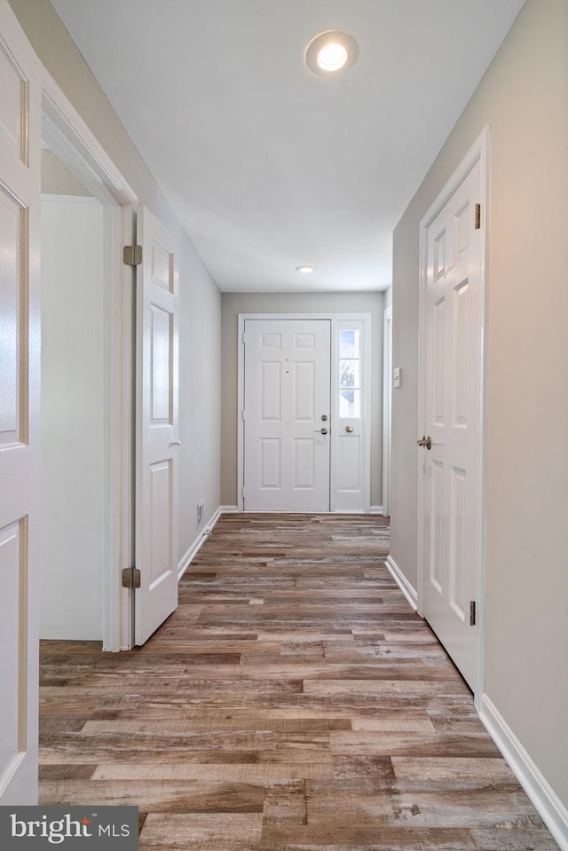 foyer entrance with baseboards and wood finished floors