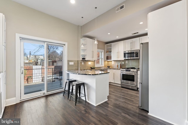 kitchen with visible vents, backsplash, appliances with stainless steel finishes, a peninsula, and open shelves