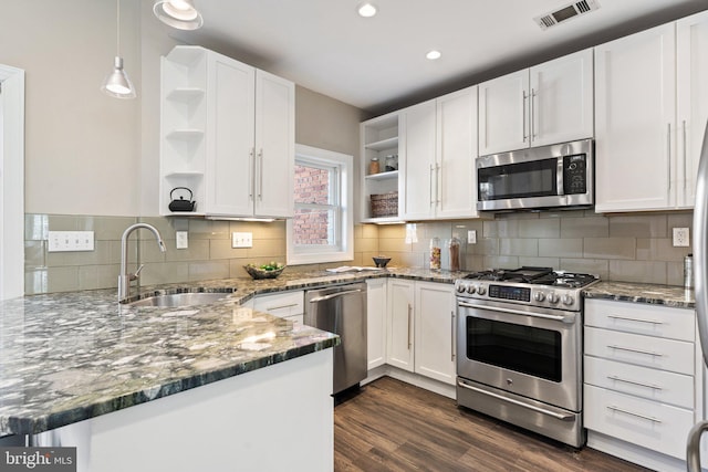 kitchen with a sink, stainless steel appliances, visible vents, and open shelves