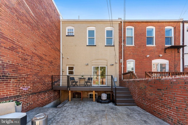 rear view of property featuring a patio and brick siding