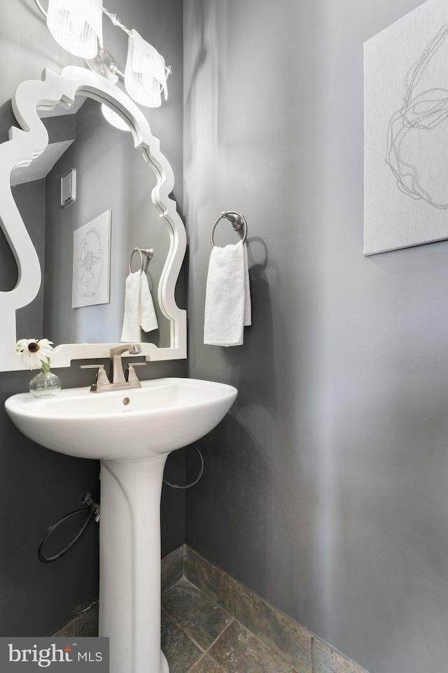 bathroom featuring stone finish flooring and baseboards